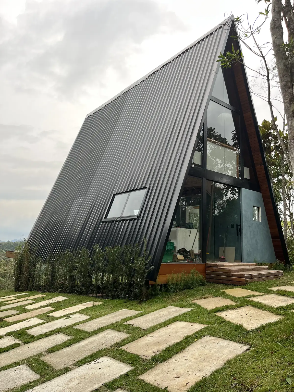 Cabana de luxo em formato A-frame iluminada ao anoitecer